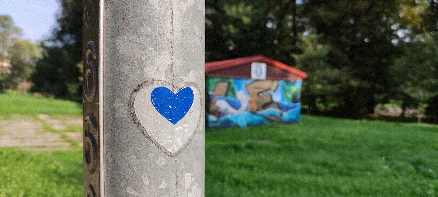 Srdce na sloupku přes barevnou budovou